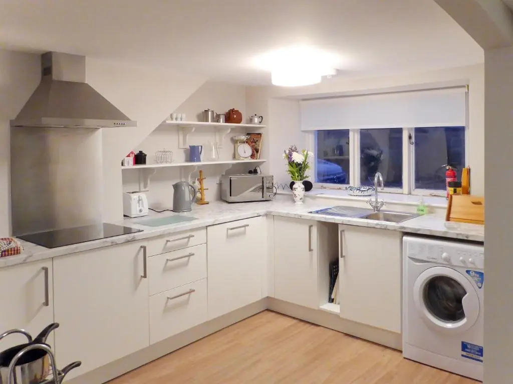 a white kitchen with a sink and a dishwasher at The White House in Pitlochry