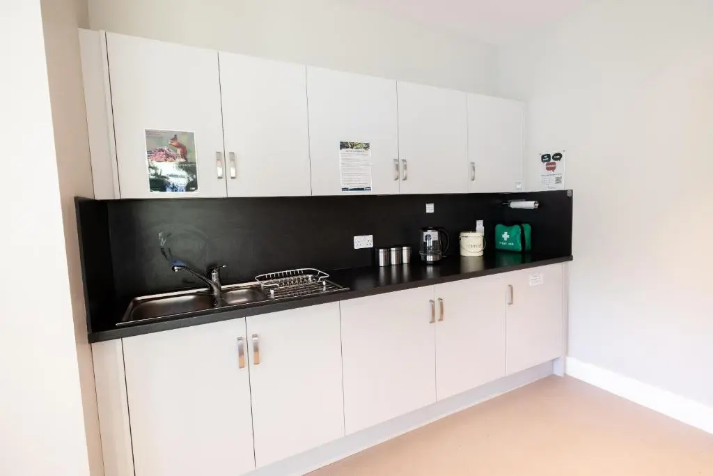 a kitchen with white cabinets and a sink at An Spiris Accommodation at Dundreggan Rewilding Centre in Dundreggan
