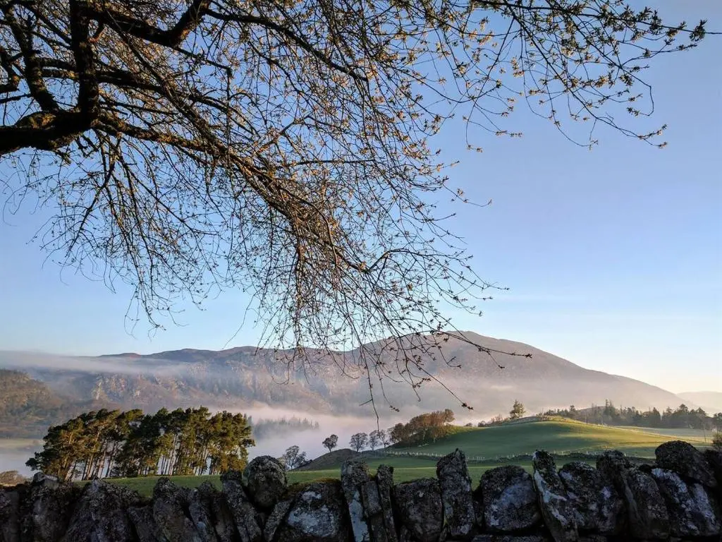 a misty valley with a mountain in the background at Spectacular Mountain View Ecopod in Newtonmore