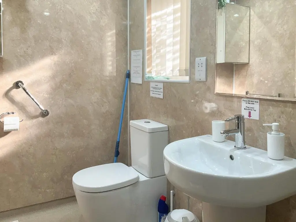 a bathroom with a white toilet and a sink at Thistle Dubh in Drumnadrochit