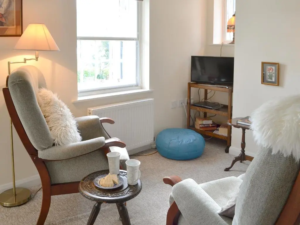 a living room with two chairs and a television at Temple House West in Drumnadrochit