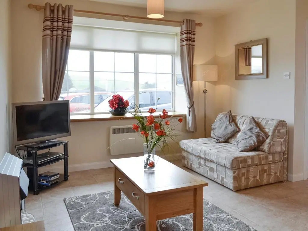 a living room with a couch and a tv at Pennan Lodge - 26818 in Pennan