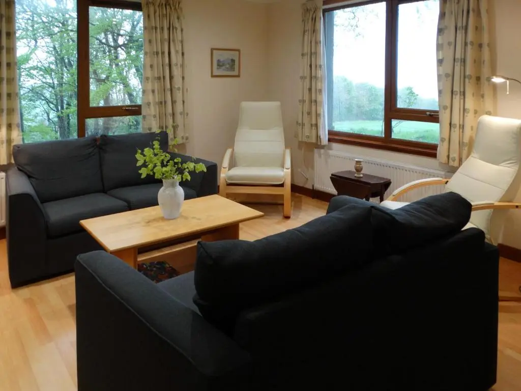 a living room with a couch and a table at Scobach Lodge in Turriff