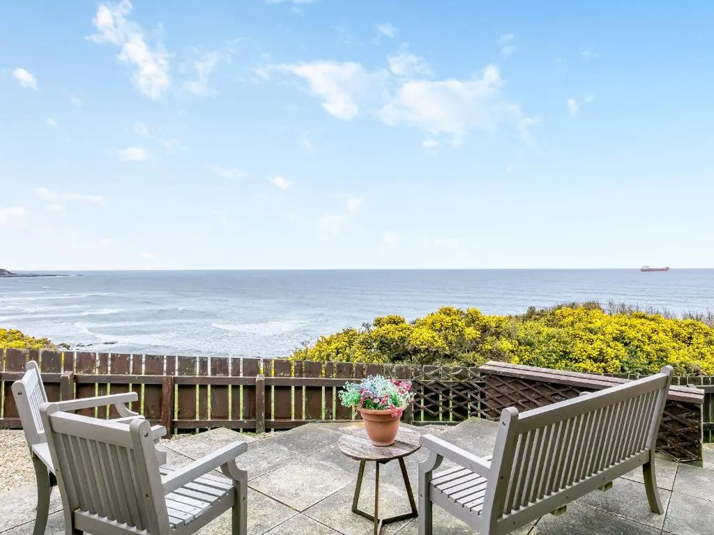 a patio with two chairs and a table and the ocean at Ocean View - 28045 in Banff