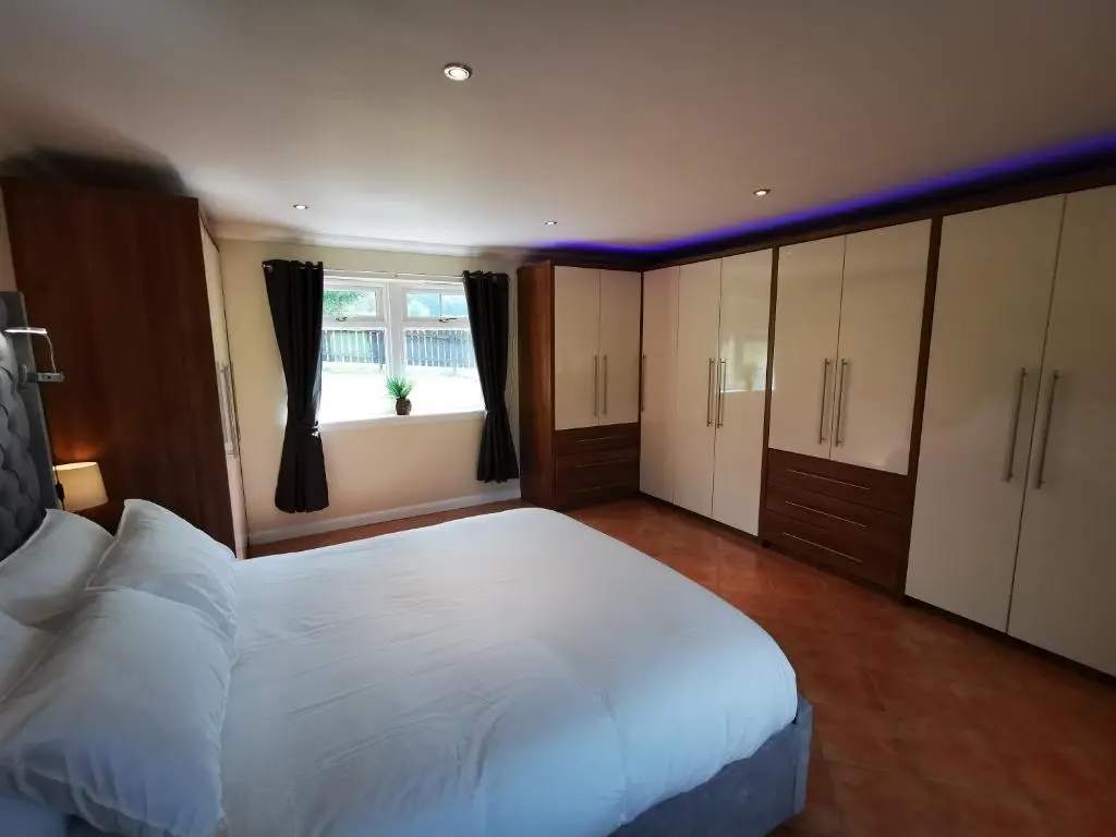 a bedroom with a large white bed and a window at Private peacefull pet friendly converted country cottage in Keig
