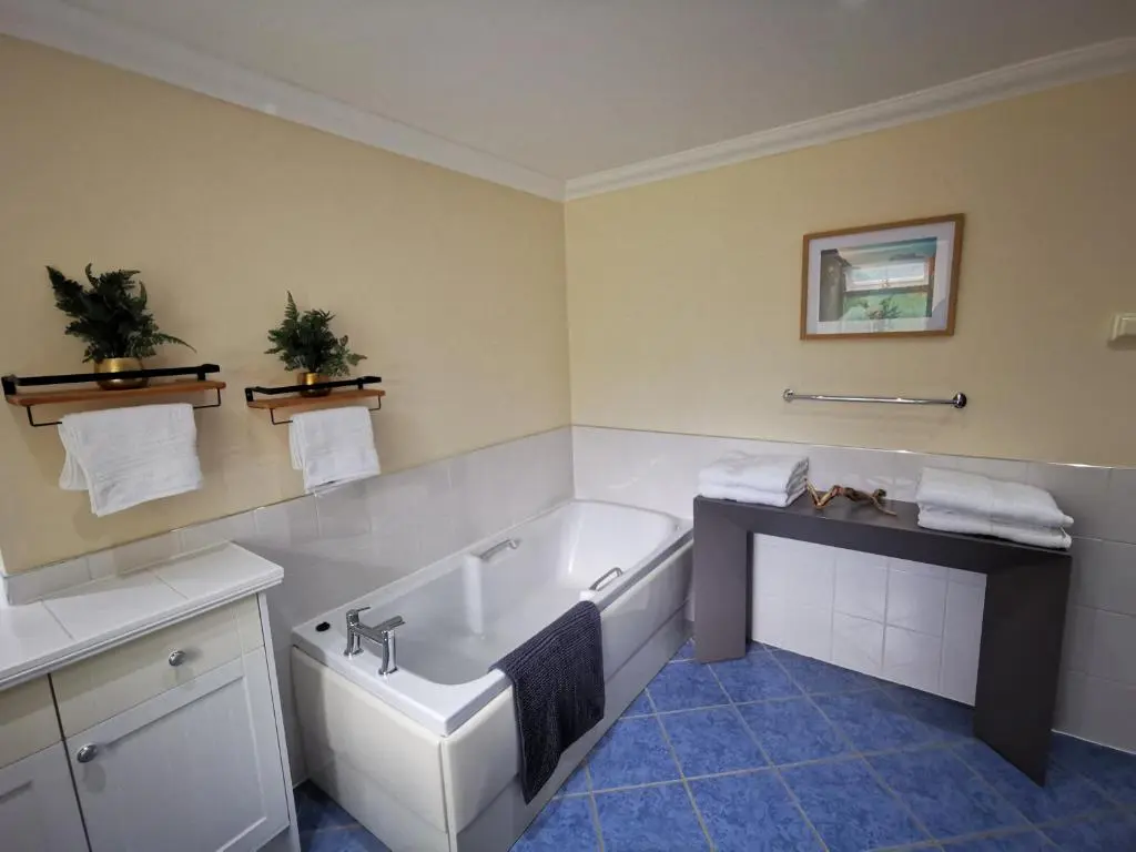 a bathroom with a tub and a sink at Private peacefull pet friendly converted country cottage in Keig