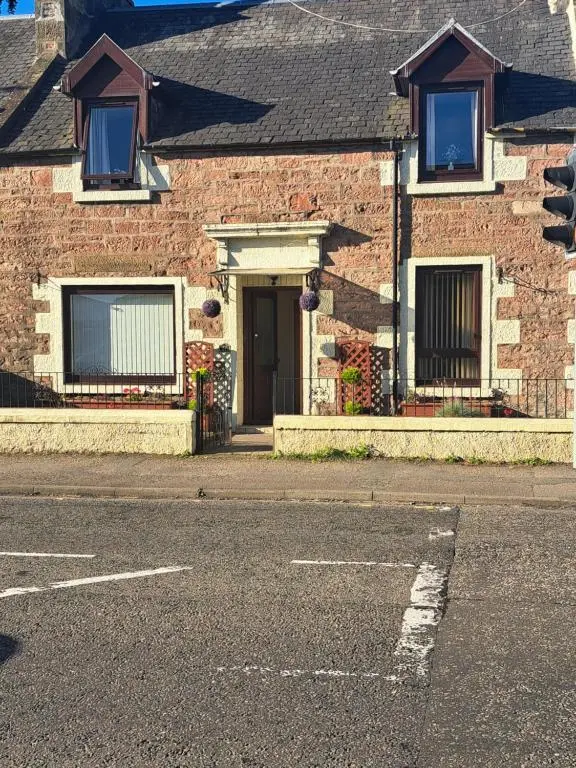 a brick house with a door on a street at No 27 in Inverness