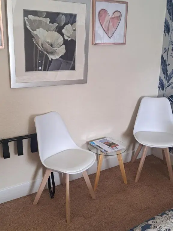 two white chairs and a table in a room at No 27 in Inverness
