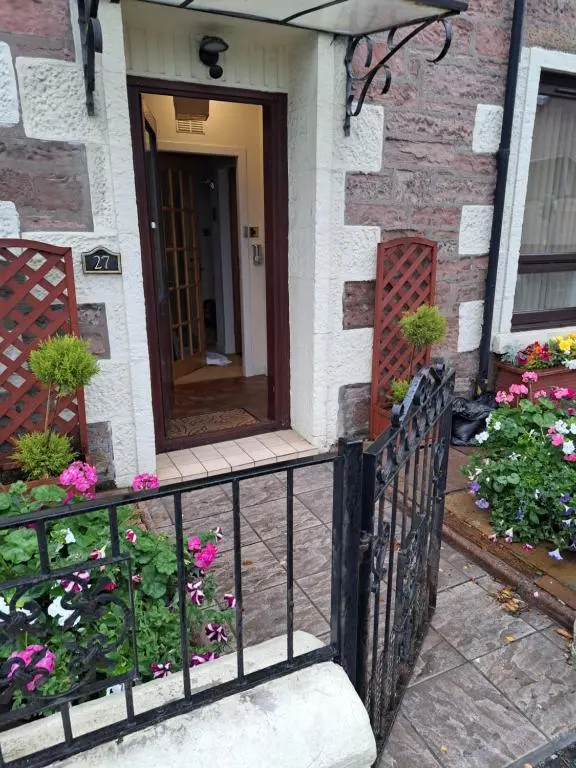 a house with a black fence and flowers at No 27 in Inverness