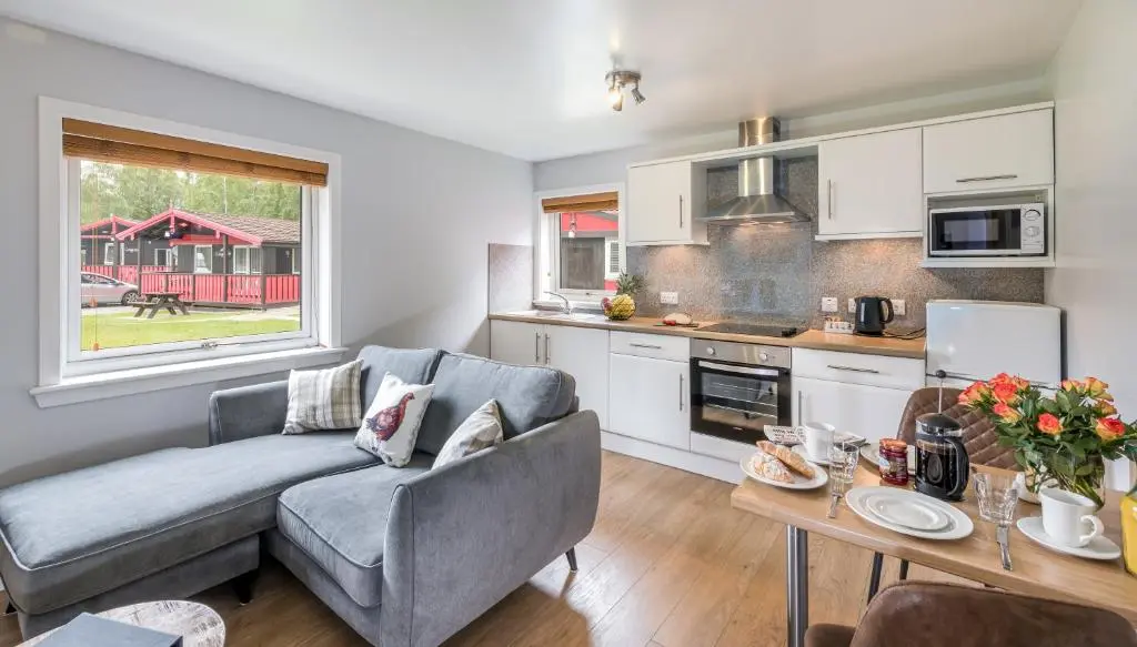 a living room with a couch and a table at High Range Self-Catering Chalets in Aviemore