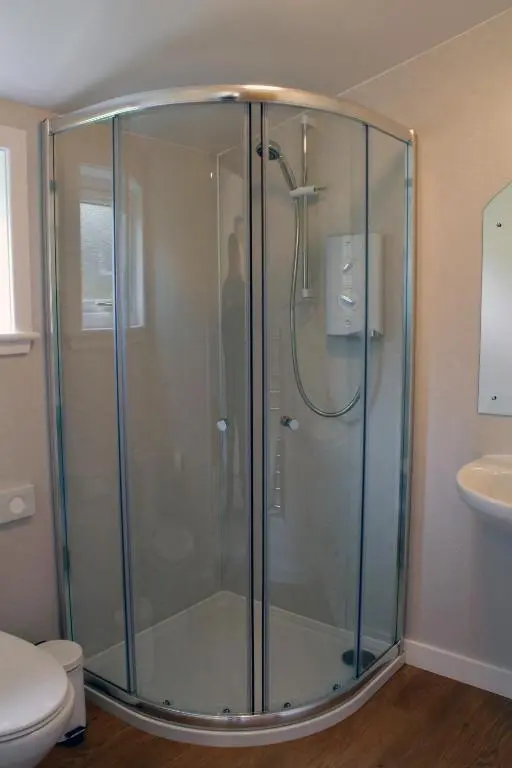 a glass shower in a bathroom with a toilet at High Range Self-Catering Chalets in Aviemore