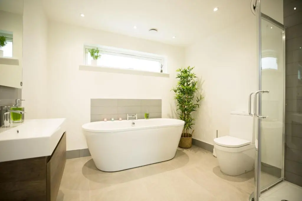 a white bathroom with a tub and a toilet at Tomdhu Lodge - Seasgair Lodges in Boat of Garten