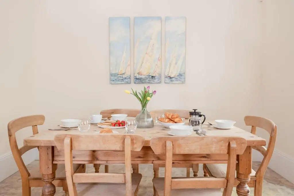 a wooden table with chairs and a table with food on it at Craigard Lodge - Seasgair Lodges in Boat of Garten
