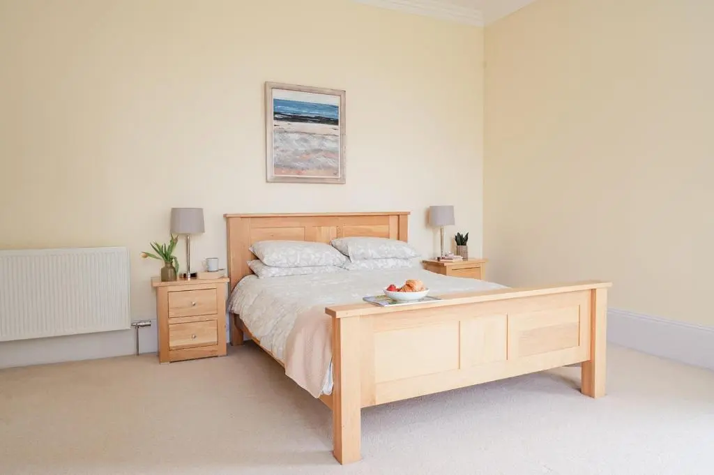 a bedroom with a bed and a table with a bowl on it at Craigard Lodge - Seasgair Lodges in Boat of Garten