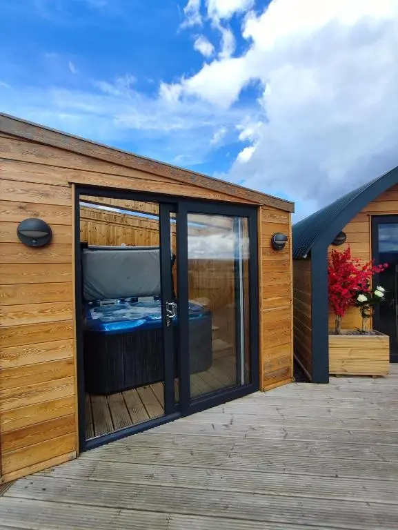 a wooden house with a large window on a deck at Knockan in Keith