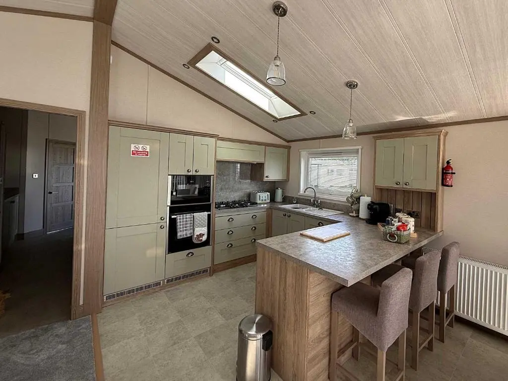 a kitchen with a island in the middle of it at Highland Holiday Getaways - The Heilan' Lodge in Embo
