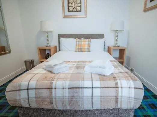 a bedroom with a large bed with two towels on it at Nairn View Guest House in Nairn