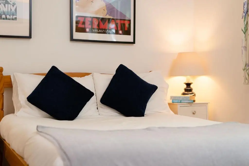 a bed with two black pillows on top of it at Langrick in Nethy Bridge