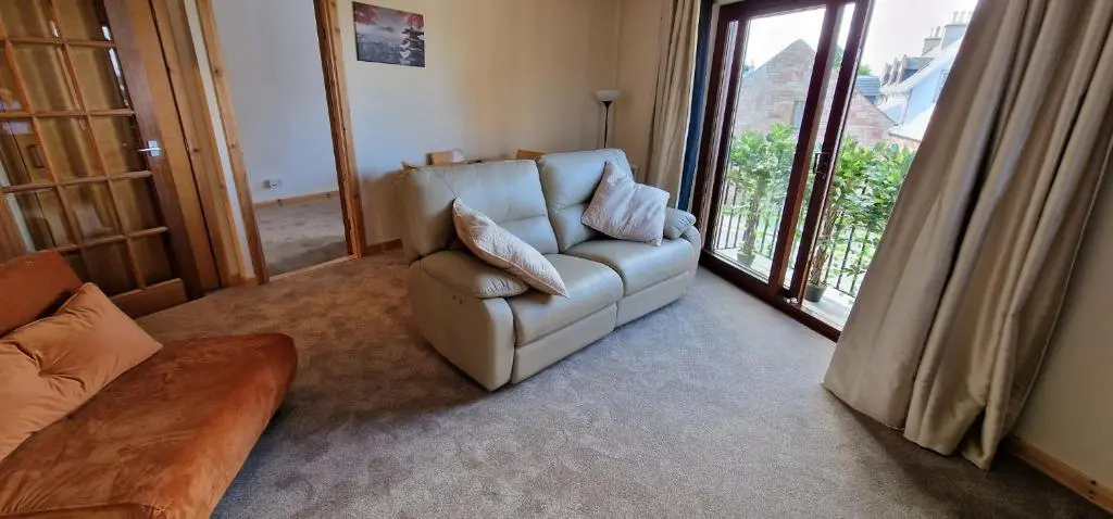 a living room with a couch and a chair at Colin Young Place in Nairn