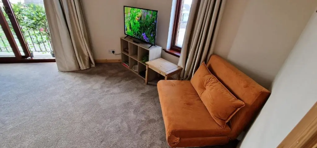 a living room with a couch and a flat screen tv at Colin Young Place in Nairn