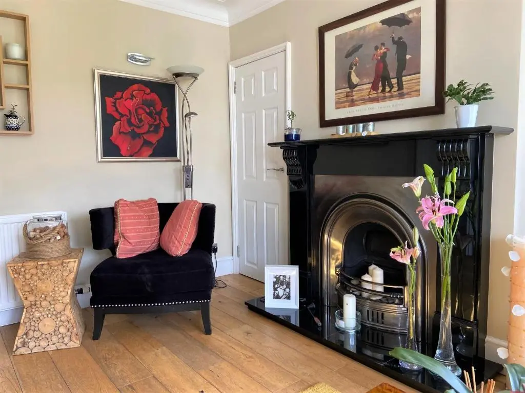 a living room with a black chair and a fireplace at 26 Green Drive Inverness in Inshes