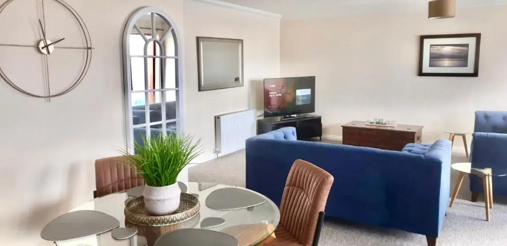 a living room with a blue couch and a table at Riverview Apartment 2 bed, 2 bath, Free Parking / WiFi in Inverness