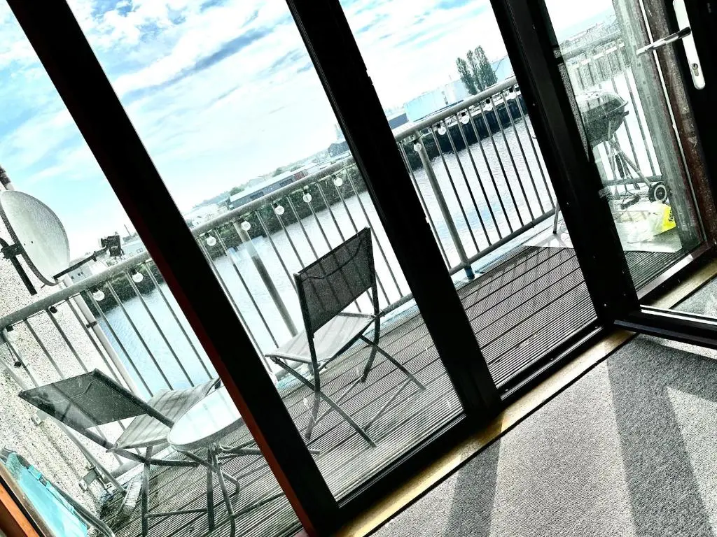 a balcony with a chair and a view of the water at Riverview Apartment 2 bed, 2 bath, Free Parking / WiFi in Inverness