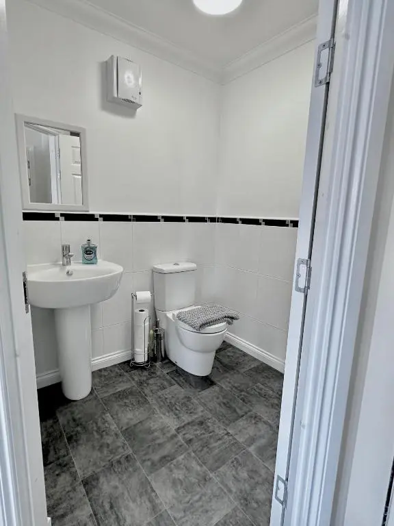 a white bathroom with a toilet and a sink at Riverview Apartment 2 bed, 2 bath, Free Parking / WiFi in Inverness