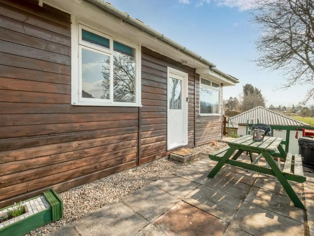 a picnic table in front of a house at Holiday Home Lochness by Interhome in Contin