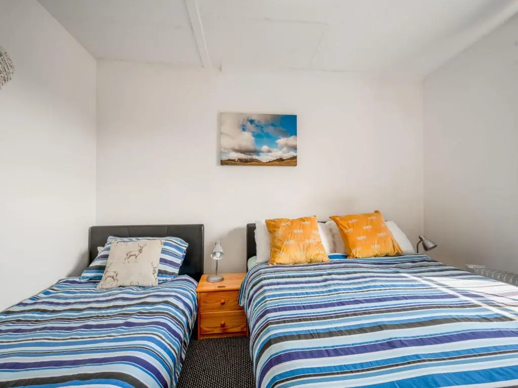 two beds sitting next to each other in a bedroom at Holiday Home Lochness by Interhome in Contin