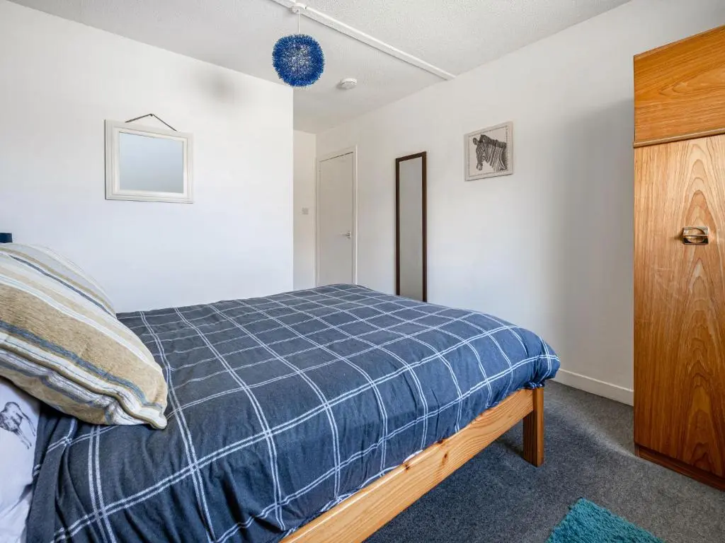 a bedroom with a bed and a wooden cabinet at Holiday Home Isle of Skye by Interhome in Contin