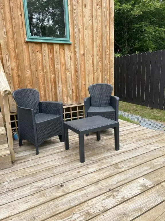two chairs and a table on a deck at 1Lochness glam lodges in Inverness