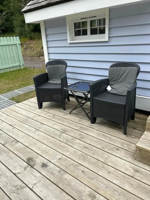 two chairs and a table on a deck at 1Lochness glam lodges in Inverness