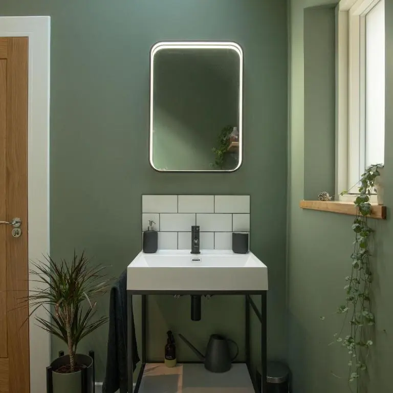a bathroom with a white sink and a mirror at Arbor Nethy Bothy in Cairngorms National Park in Nethy Bridge