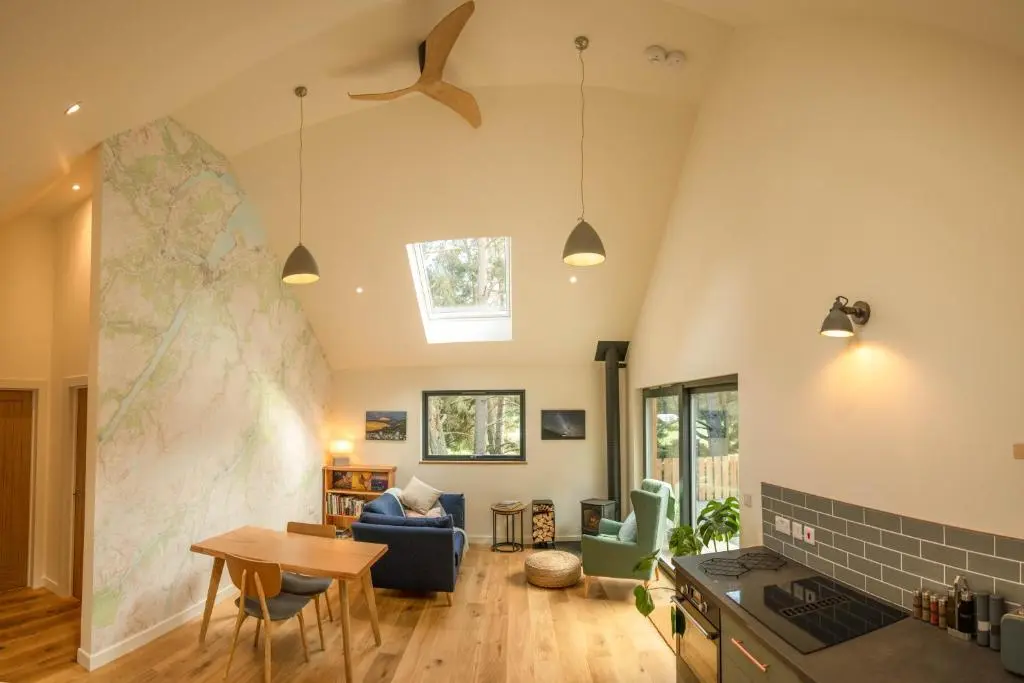 a kitchen and living room with a map on the wall at Arbor Nethy Bothy in Cairngorms National Park in Nethy Bridge
