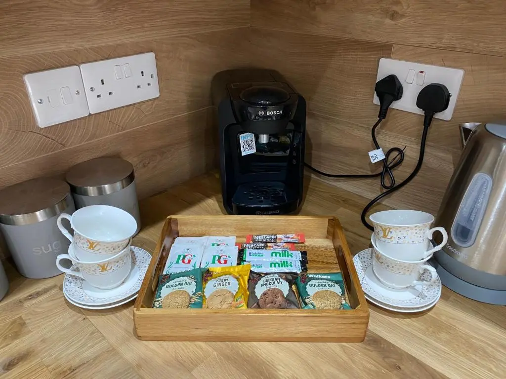 a box of cookies and cups and a coffee maker at 51 Innes Street Apartment in Inverness