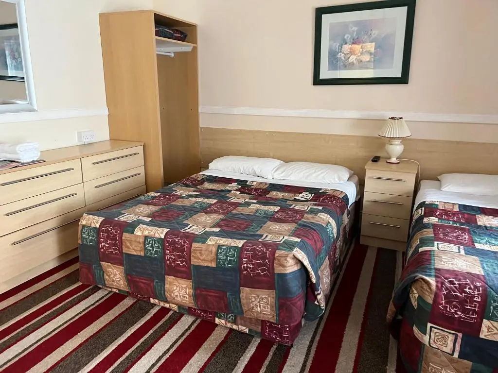 a hotel room with two beds and two cabinets at Strathpeffer Hotel in Strathpeffer