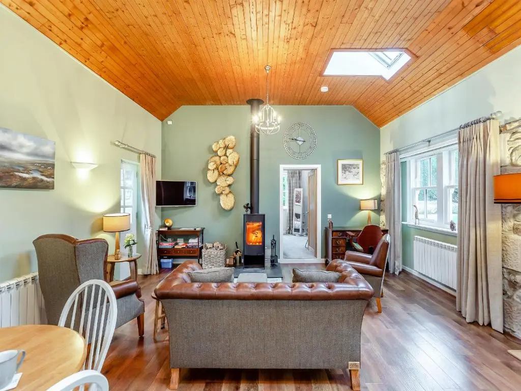 a living room with a vaulted ceiling and a couch at The Bothy in Lochend