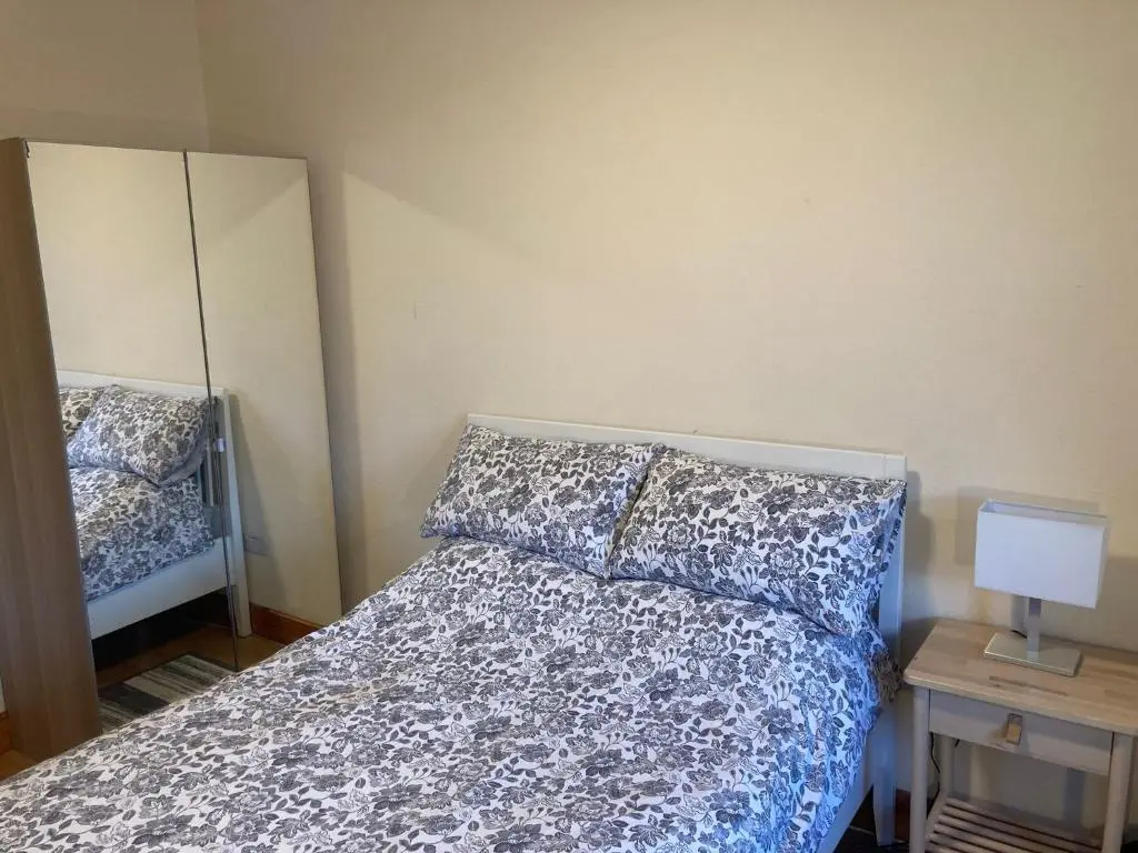 a bedroom with a bed and a mirror at 2 Bed Central Ness Apart - May Court in Inverness
