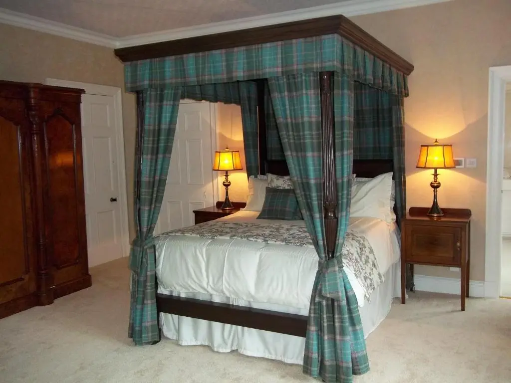 a bedroom with a bed with a plaid canopy at Carnach House in Nairn