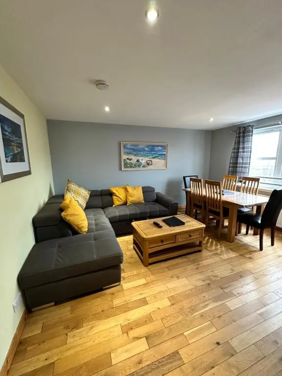a living room with a black couch and a table at Metro 8 Inverness City Centre in Inverness