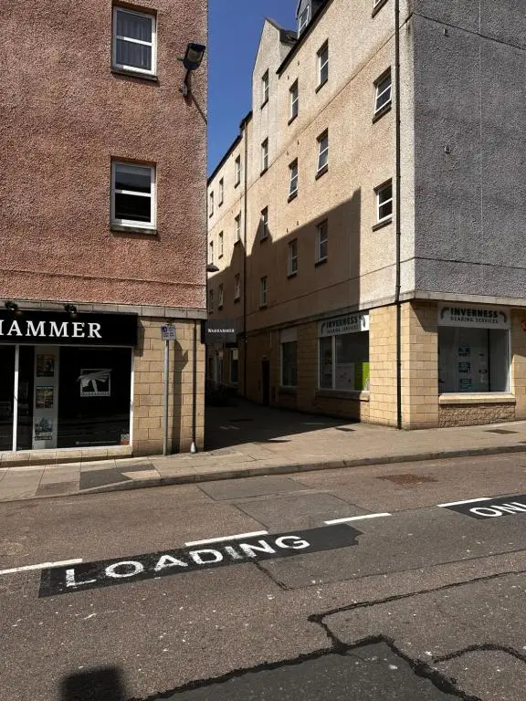an empty street next to two buildings with the wordslordslords at Metro 8 Inverness City Centre in Inverness