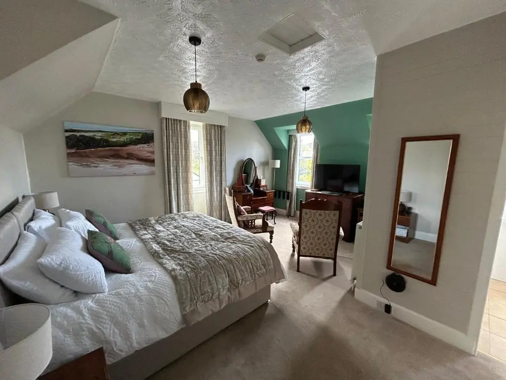 a bedroom with a bed and a desk and a mirror at Glen Lyon Lodge Bed and Breakfast in Nairn