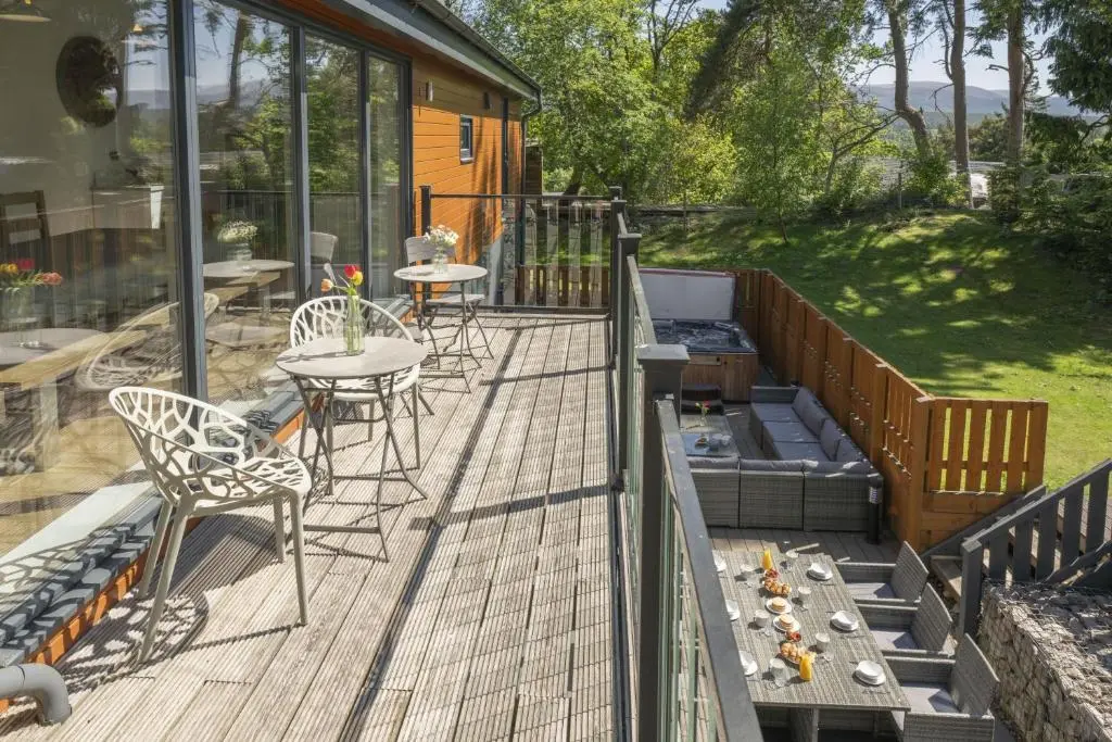 a deck with a table and chairs and a table and chairs at The Neuk in Kincraig