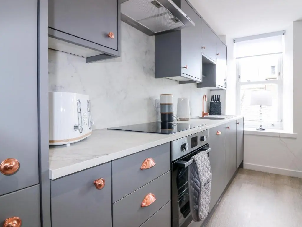 a kitchen with gray cabinets and a stove top oven at 111A Main Street in Banff