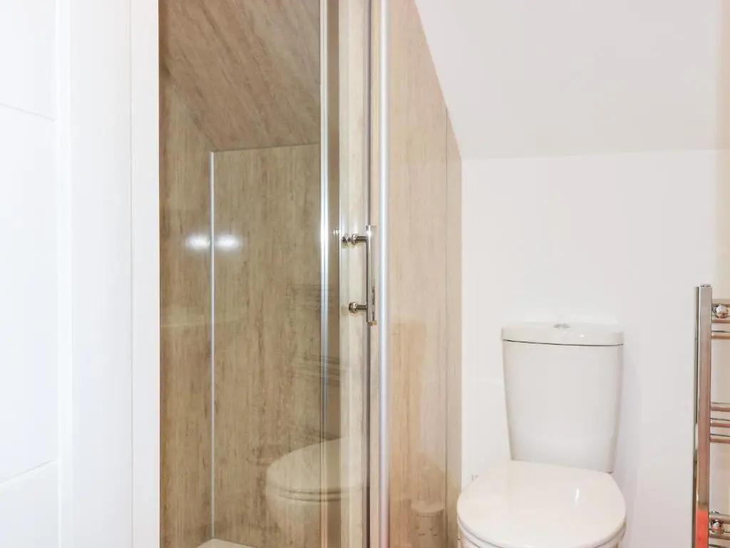 a bathroom with a toilet and a glass shower at 111A Main Street in Banff