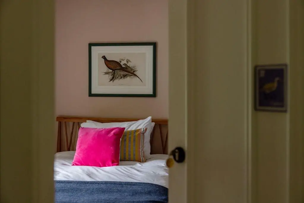 a bedroom with a bed with a pink pillow at Exclusive use - The Coach House in Banchory