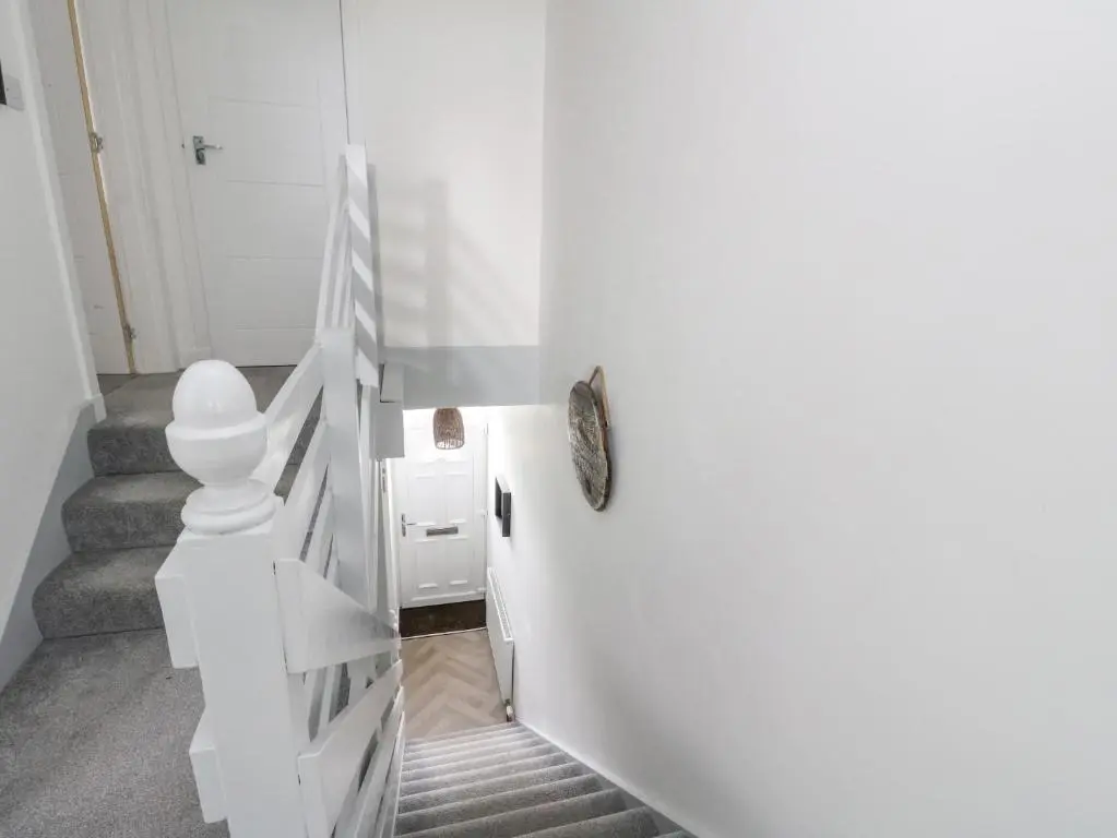 a white staircase in a home with a white railing at Anchor Cottage in Elgin