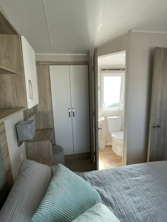 a bedroom with a bed and a bathroom at Fairview Caravan Hire in Lossiemouth