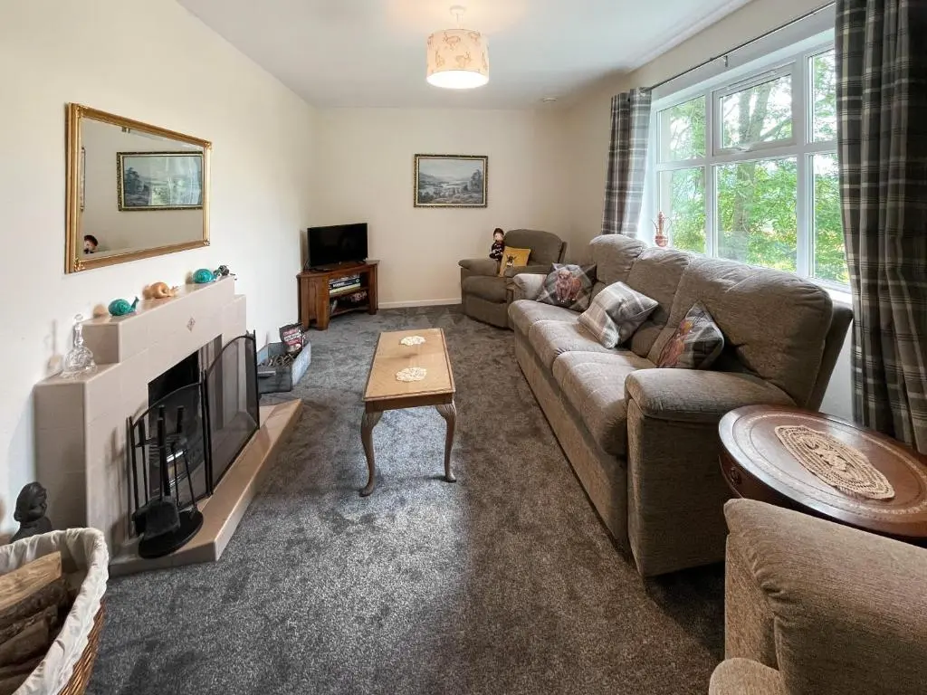 a living room with a couch and a fireplace at Muir Cottage - Uk44788 in Bridge of Alford